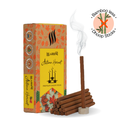 A box of Glareen Bamboo-less Incense Sticks with a single stick burning, smoke rising, and an eco-friendly label noted as 'Bamboo-less Dhoop Sticks'. The packaging is adorned with autumn-themed designs and the product is described as being charcoal-free for a pure fragrance.