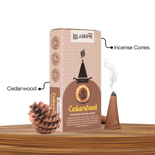 A box of Cedarwood incense cones from Le Sareen, with an illustration of a cone on fire, emitting smoke. A natural cedarwood cone is shown beside the box, and a lit cone with smoke rising is depicted on the box.
